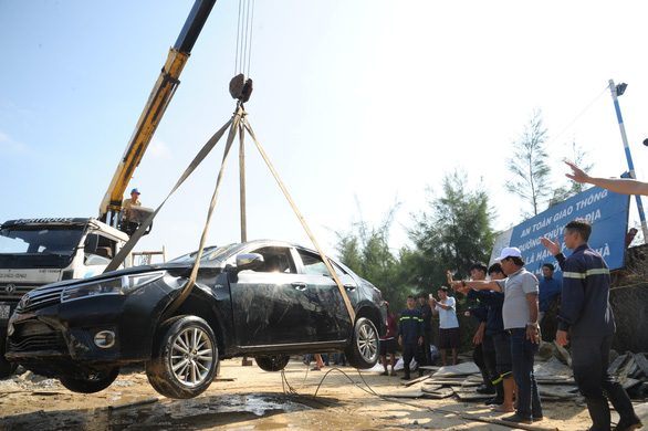 The car is seen above the ground after it is carried from the Hoai River in Hoi An City, central Vietnam, January 25, 2019. Photo: Tuoi Tre