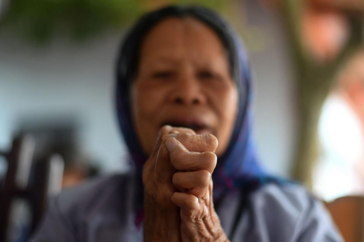 A leprosy survivor offering prayers on the 15th day of the lunar month at a pagoda in the Van Mon Leprosy Hospice compound on Jan 20, 2019. Photo: AFP