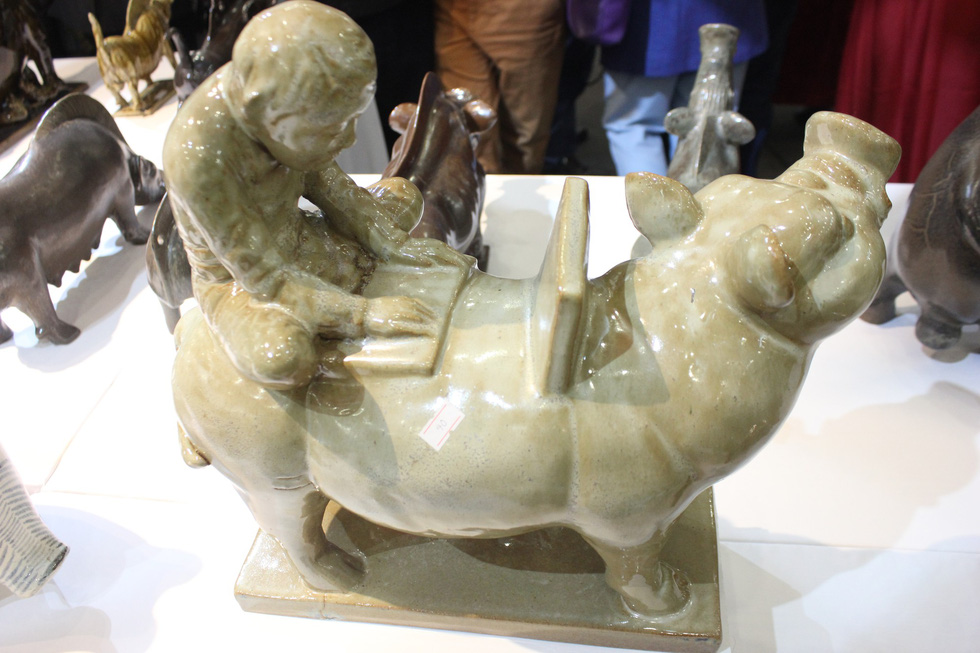 A figurine depicts a child using a laptop on a pig’s back – a blend between tradition and modern vibes. Photo: Thien Dieu / Tuoi Tre