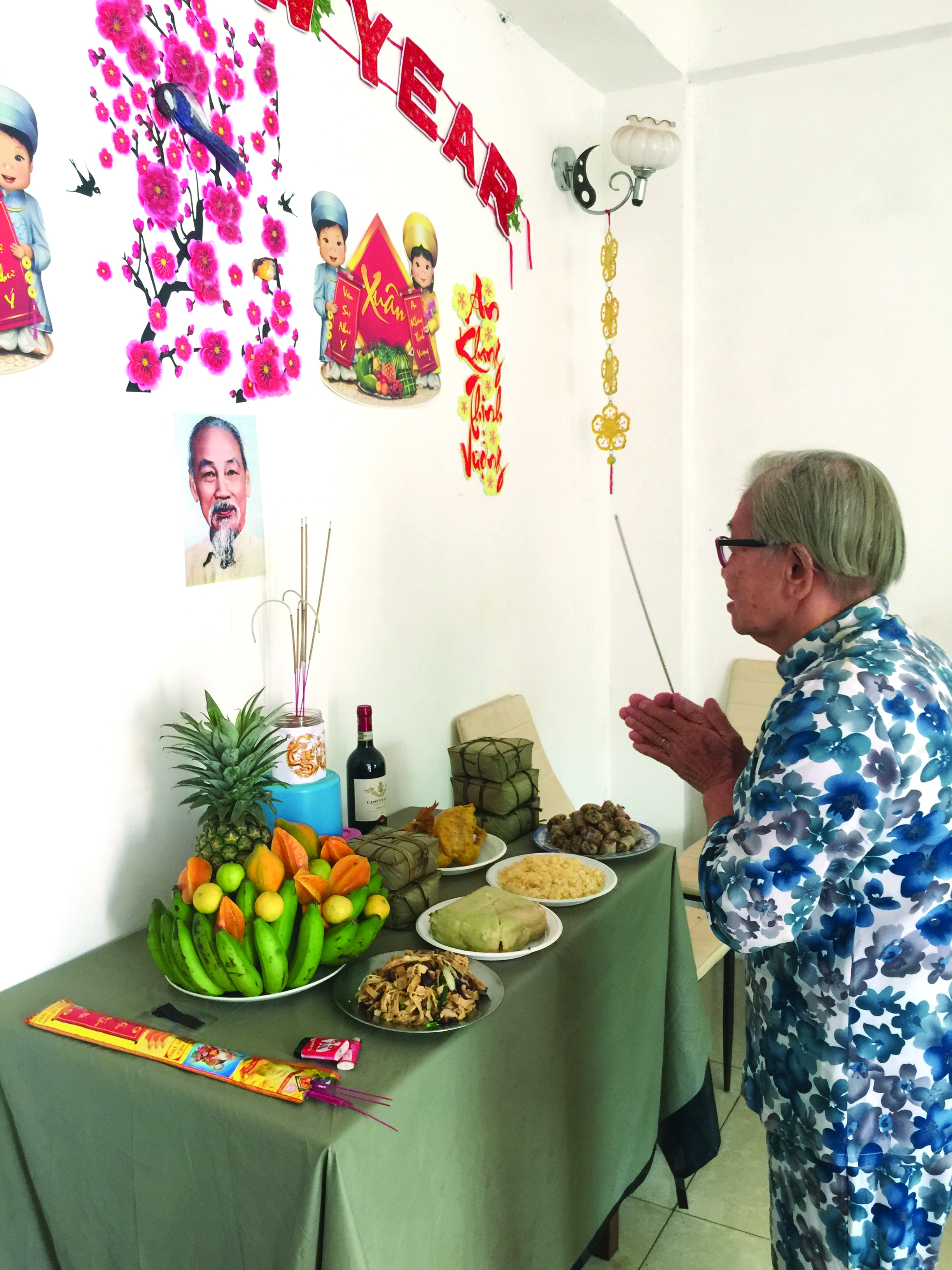 Luyen, a Hanoi-born woman who has lived nearly 70 years away from Vietnam, offers incense to her ancestors. Photo: Dinh Duc Long