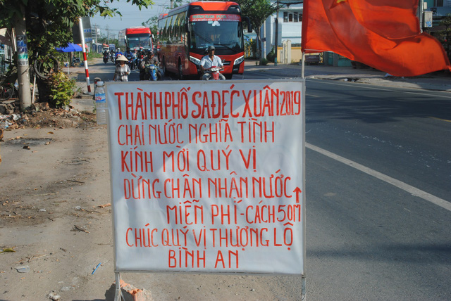 A sign Nguyen Van Thanh puts ahead of the location where he gives free drinking water to motorcyclists is pictured on a road in Dong Thap Province, southern Vietnam, January 30, 2019. The sign reads “Sa Dec City – Tet 2019. Bottled water given with affection. Please stop to receive free drinking water 50 meters from here. Have a good journey.” Photo: Thanh Nhon / Tuoi Tre