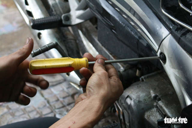 A mechanic repairs a motorbike for free during a rainstorm in Da Nang in December 2018. Photo: Doan Nhan / Tuoi Tre