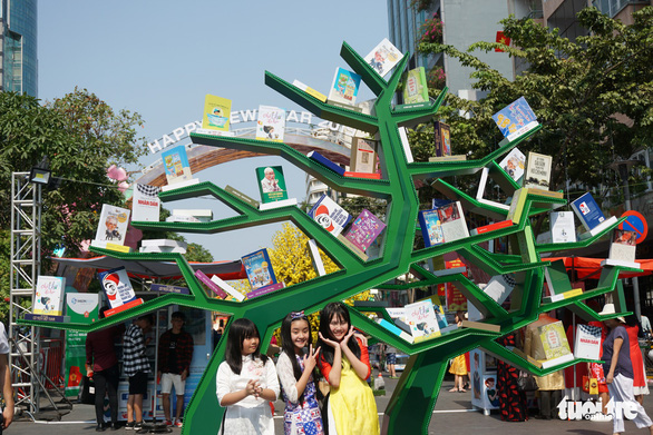  Young visitors take a photo at the book street. Photo: Tuyet Kieu / Tuoi Tre