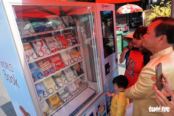  Visitors check out a book vending machine. Photo: Tuyet Kieu / Tuoi Tre