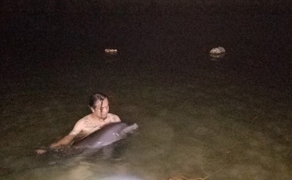 A SaSa member helps a dolphin named Mun [Black]. Photo: Le Chien / Tuoi Tre