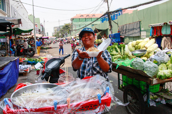  A resident sells food on a motorbike at the market.