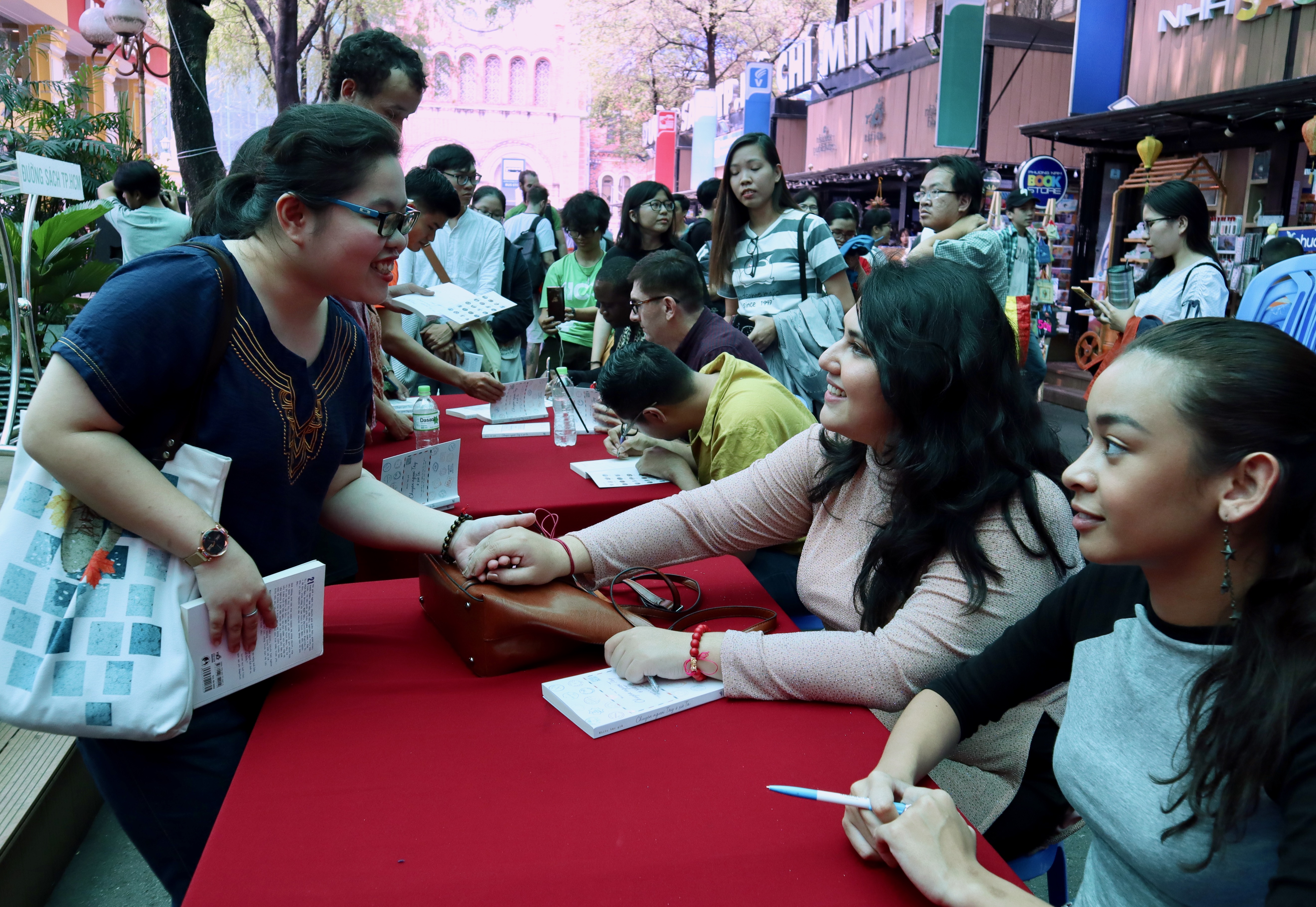 Sevinch, one of the authors, holds hands with a reader. Photo: Ha My / Tuoi Tre News
