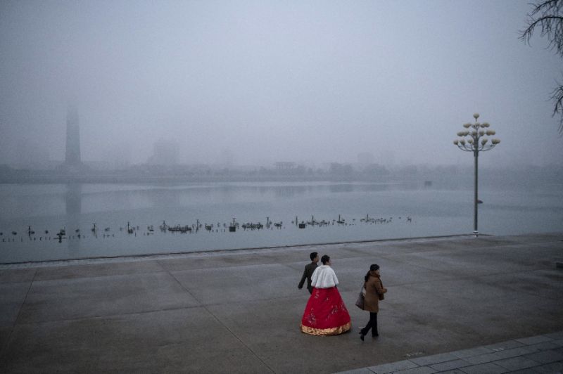 I do: A bride and groom walk along Pyongyang's Taedong river on a foggy evening. Photo: AFP