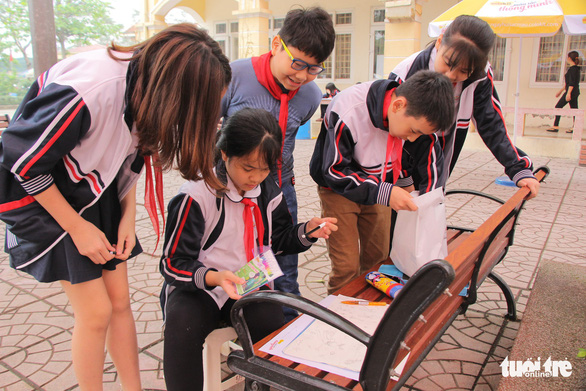Students gather to praise a schoolmate’s piece of art. Photo: Ha Thanh / Tuoi Tre