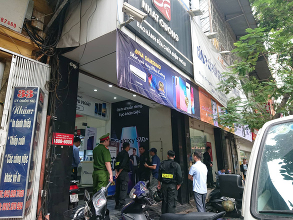 Officers examine an outlet on Ly Quoc Su Street.