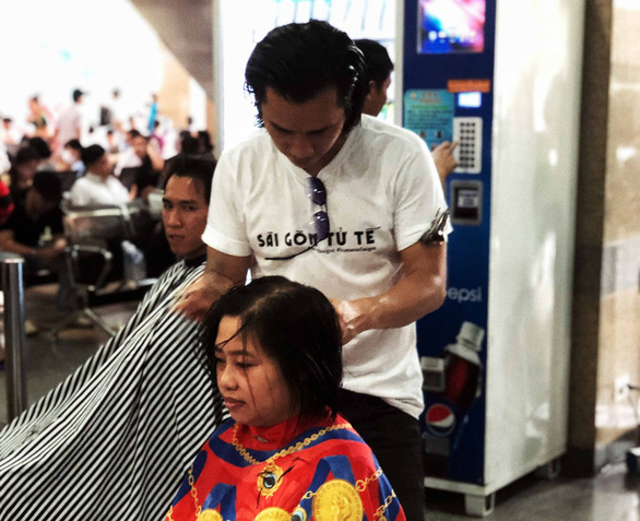 Vietnamese hairstylist Le Tuan gives poor people free haircuts to promote “A Beautiful Saigon” project. Photo: Le Van / Tuoi Tre