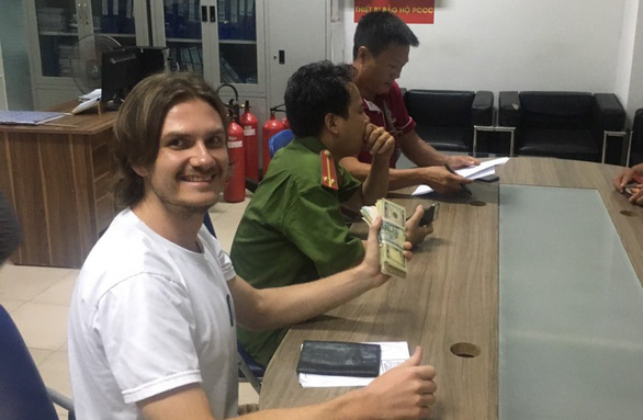 Ukrainian Artern smiles happily he receives his money. Photo: Tan Tai / Tuoi Tre