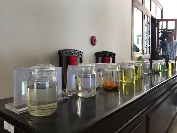 Samples of fake fuel and solution are displayed at the press conference. Photo: Trung Tan / Tuoi Tre