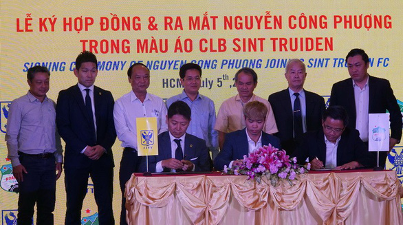 Vietnamese striker Nguyen Cong Phuong (sitting, middle) signs for Belgian first-division side Sint-Truiden at a ceremony in Ho Chi Minh City on July 5, 2019. Photo: Anh Dung / Tuoi Tre