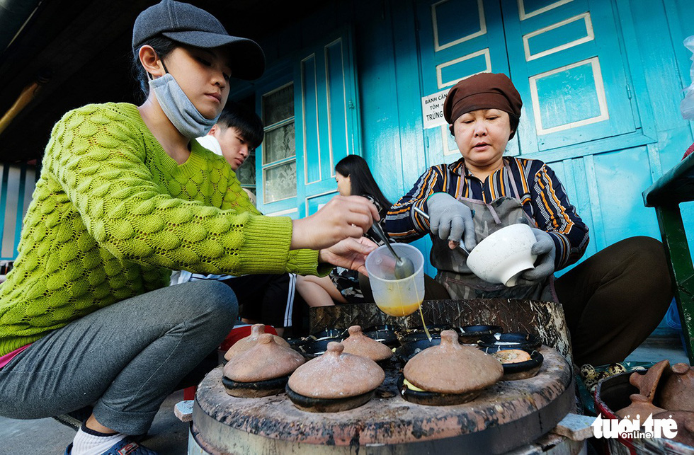  Two women cook banh can in Da Lat, Vietnam’s Central Highlands. Photo: Mai Vinh / Tuoi Tre