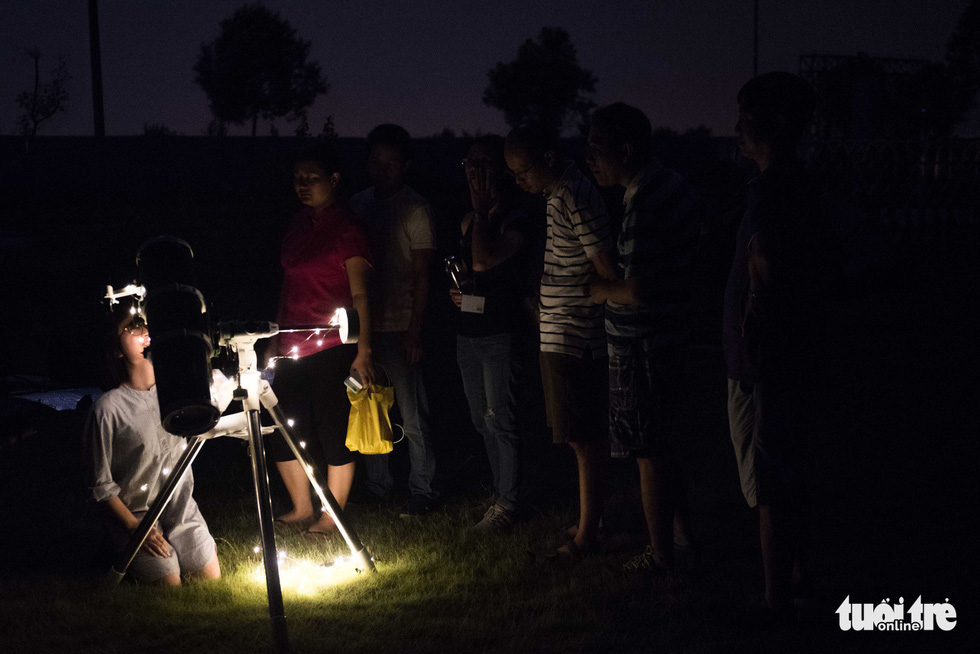 A participant looks through the telescope to watch the eclipse. Photo: Hoang Thanh Tung / Tuoi Tre
