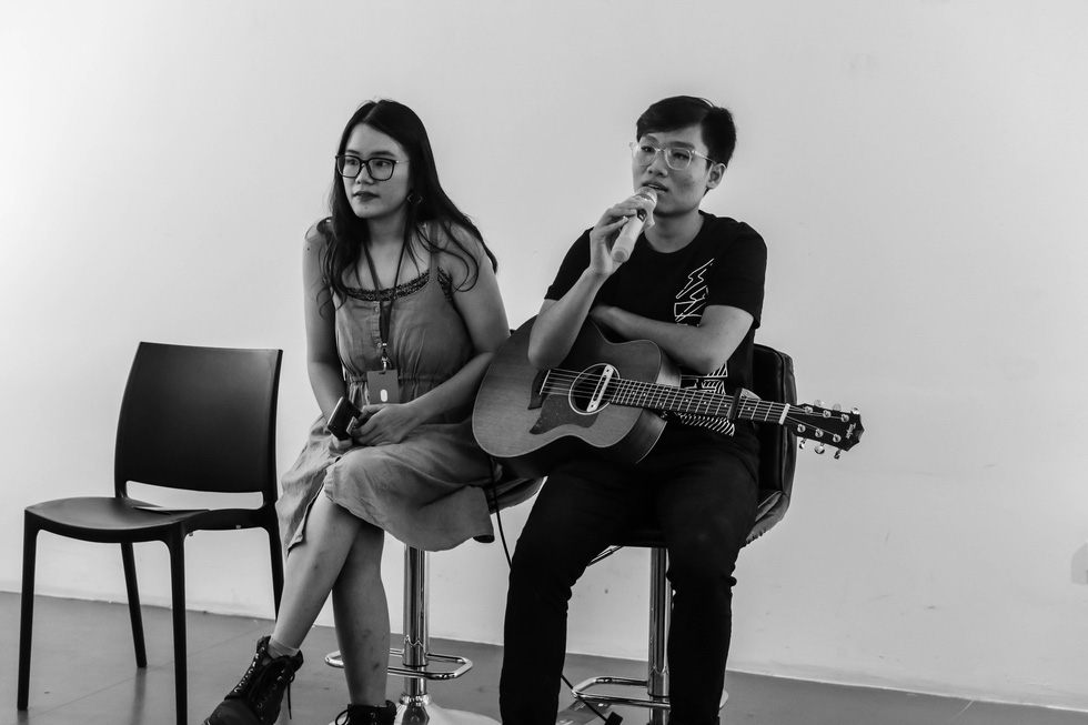 Tram Anh (left) sits on the stage during a musical performance. Photo: supplied