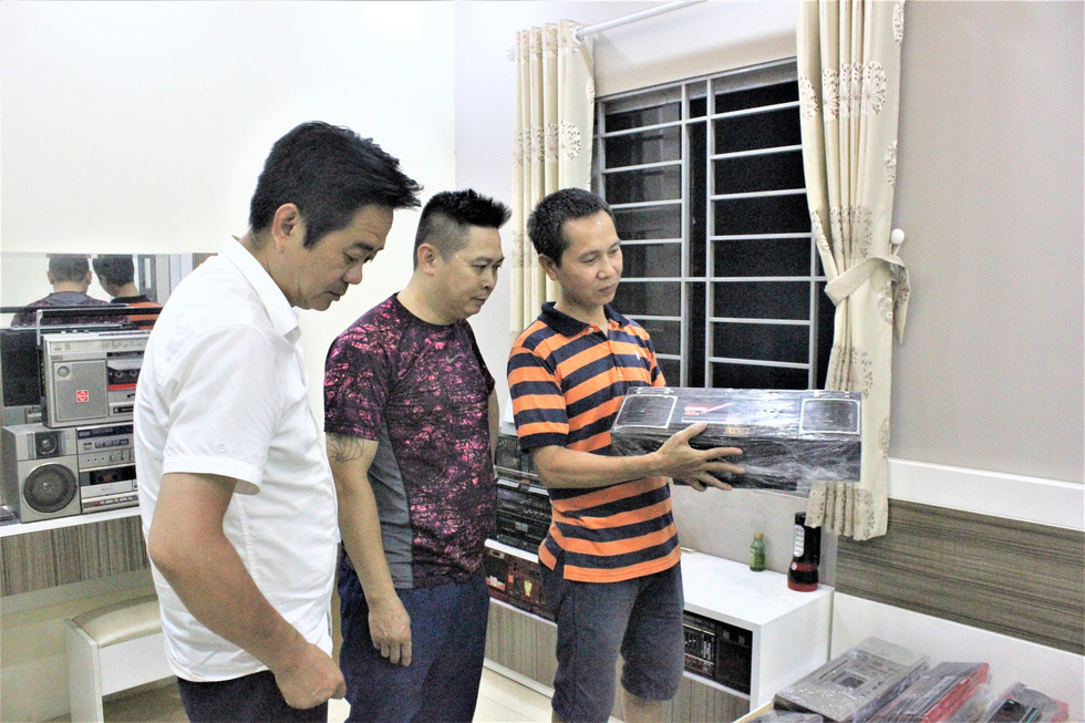 Nguyen Xuan Thuy (right) introduces his collection to Nguyen Manh Ha (left) and Dang Dai Hung, other members in radio lovers club in Hanoi. Photo: Thien Dieu / Tuoi Tre