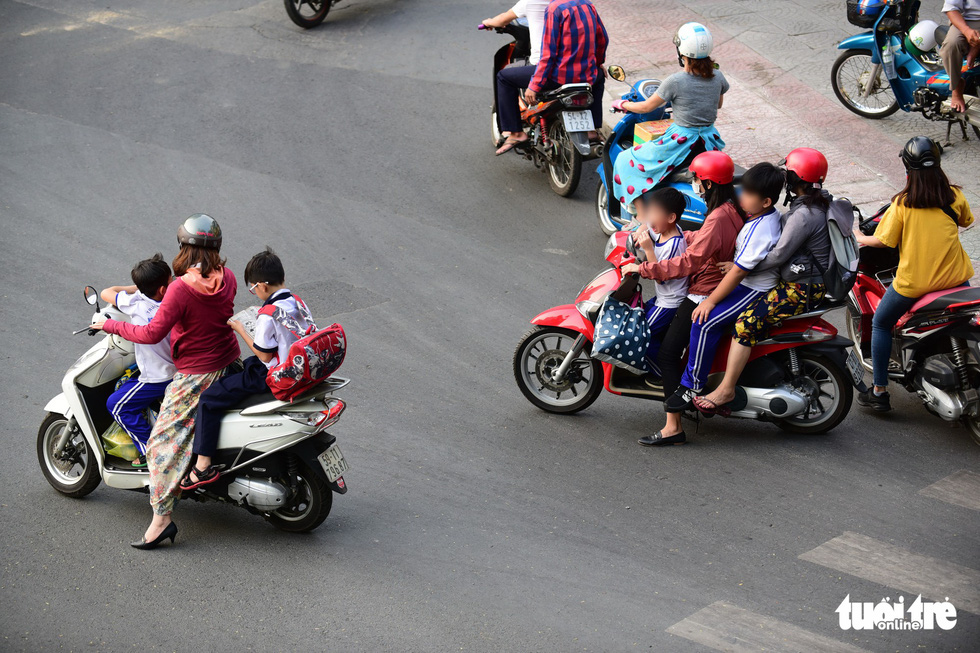 Parents wear helmets, while their children don’t on Nguyen Binh Khiem Street in Ho Chi Minh City. Photo: Quang Dinh / Tuoi Tre