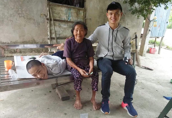 Pham Van Chau (right) smiles for a photo with Thuong, a man born with disability in Quang Ngai Province, central Vietnam. Photo: Supplied