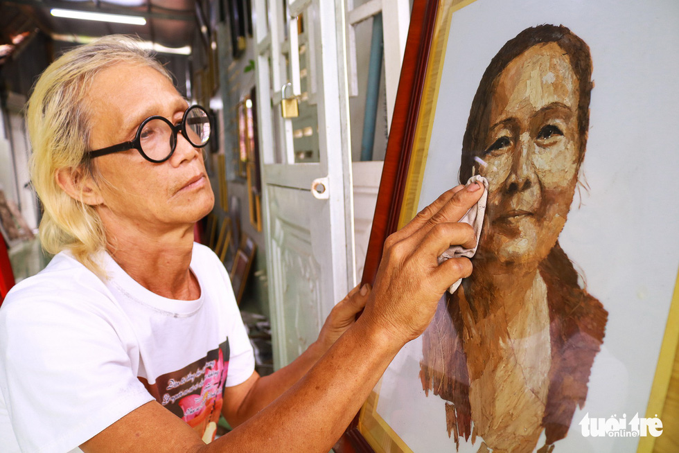 Le Van Nghia and a portrait of his late wife, made using lotus leaves Photo: Ngoc Phuong / Tuoi Tre