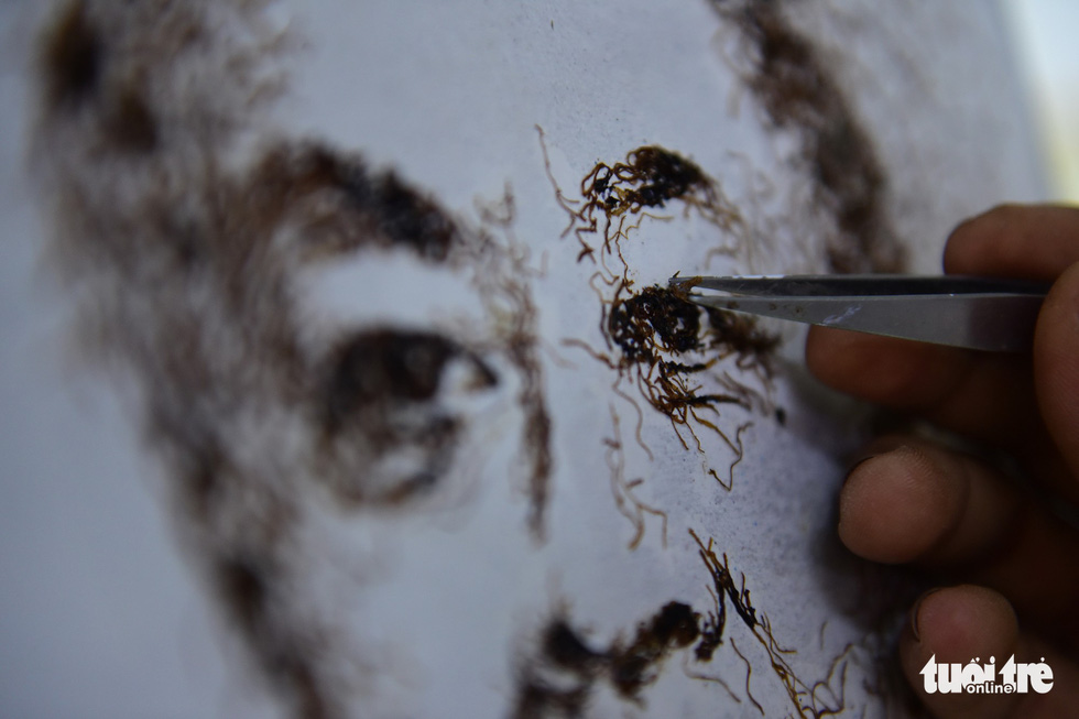 Le Van Nghia works on a new painting. Photo: Ngoc Phuong / Tuoi Tre
