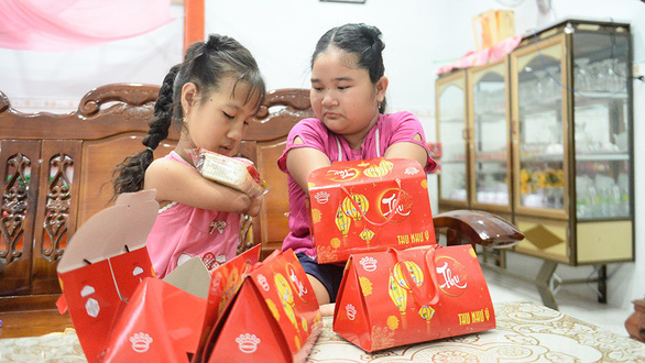 The two girls open Thao’s birthday presents in excitement. Photo: Tu Trung / Tuoi Tre