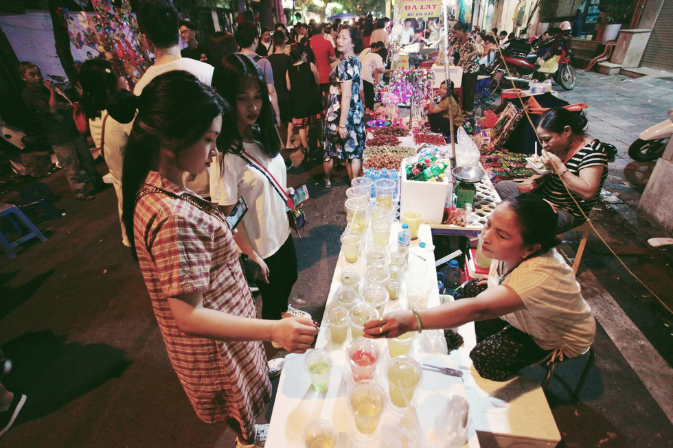 Visitors buy drinks-to-go from a street vendor on Hang Ma Street in Hoan Kiem District, Hanoi, September 13, 2019. Photo: Mai Thuong / Tuoi Tre