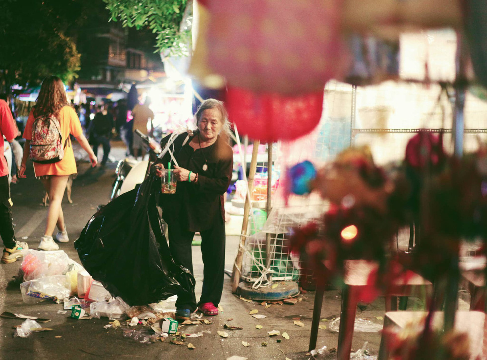 A woman collects waste littered on Hang Ma Street in Hoan Kiem District, Hanoi, September 13, 2019. Photo: Mai Thuong / Tuoi Tre