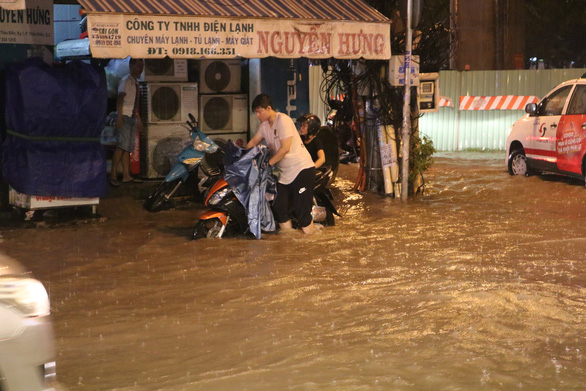A man pushes his motorbike on Thao Dien Street in District 2. Photo: Thu Hien / Tuoi Tre