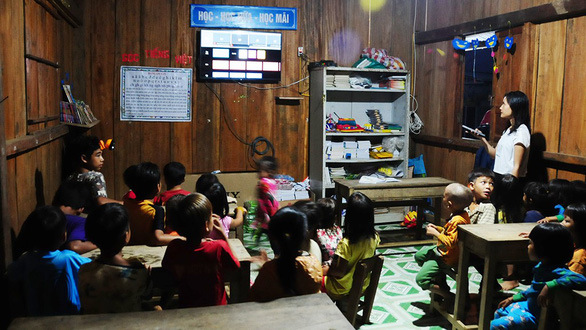 Tra Thi Thu and her students watch TV after dinner. Photo: B.D. / Tuoi Tre