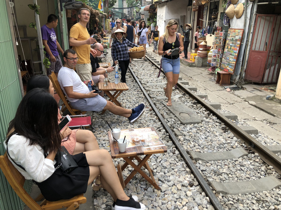Visitors have drinks at cafés next to the railway track in Hanoi before the area was blocked in an attempt of local authorities to ensure public and traffic safety. Photo: Q.TH/ Tuoi Tre