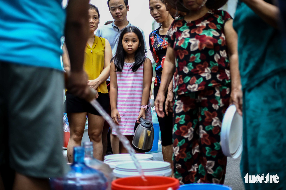 Children help their parents carry clean water in Hanoi. Photo: Nguyen Khanh / Tuoi Tre
