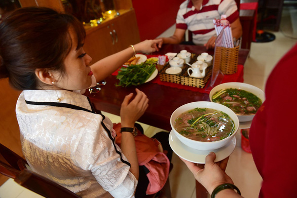 A waiter serves two bowls of pho at Pho Ngoc Linh. Photo: Quang Dinh / Tuoi Tre