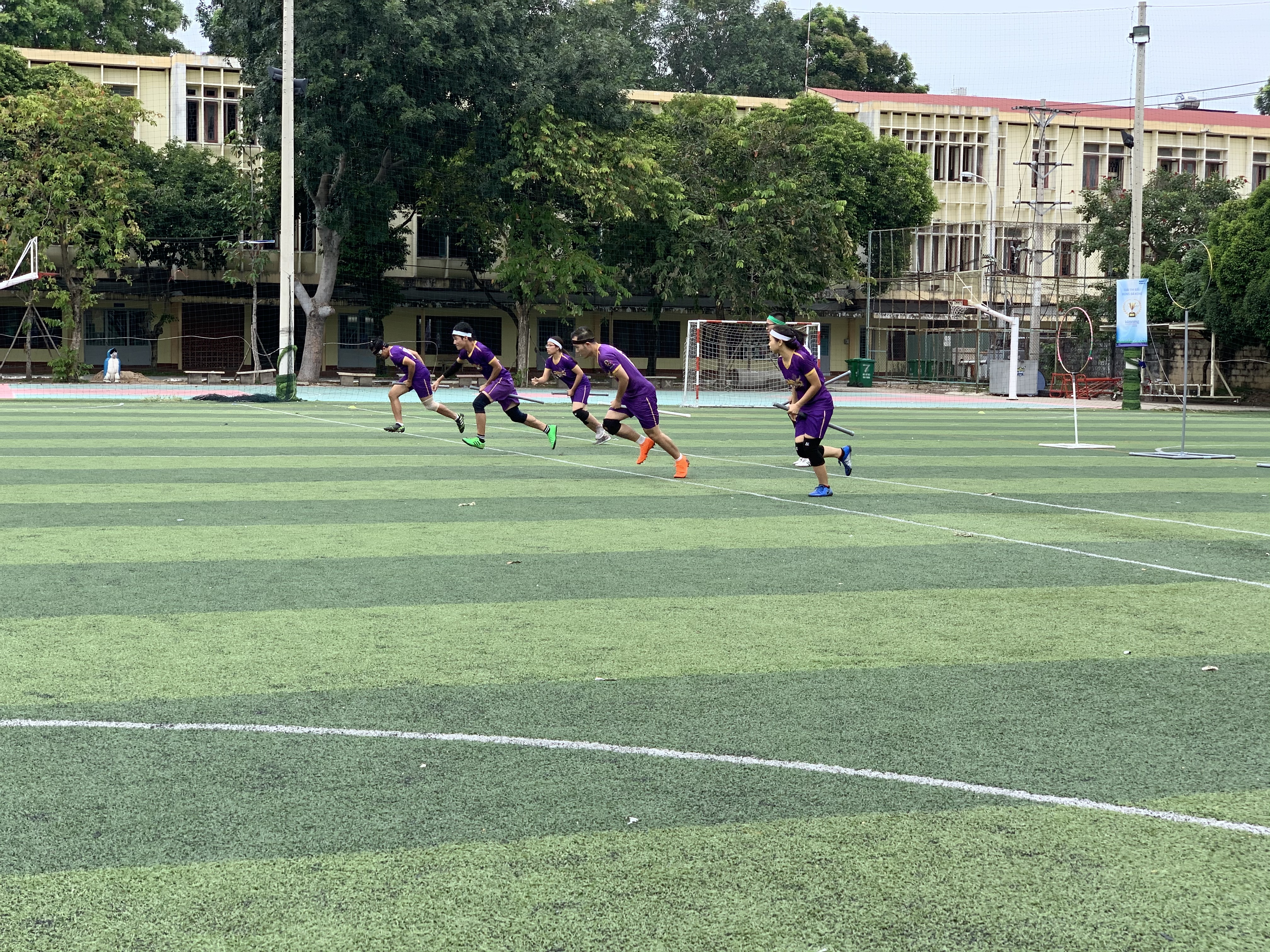 Six players of a team race towards the center line at a match in the maiden Vietnam Quidditch Cup organized by the Vietnam Quidditch Association  in Tan Binh District, Ho Chi Minh City, November 10, 2019. Photo: Bao Anh / Tuoi Tre News
