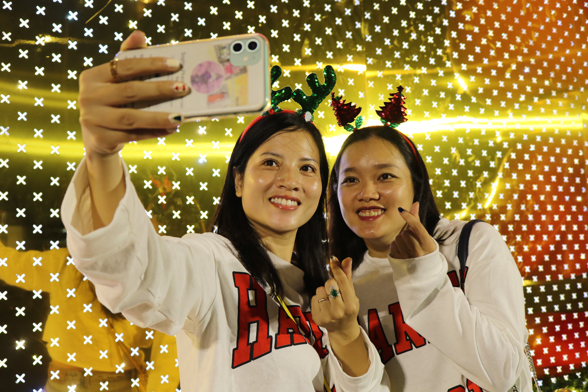 Two girls take a selfie in front of Landmark 81 Tower in Binh Thanh District. Photo: Hoang An / Tuoi Tre