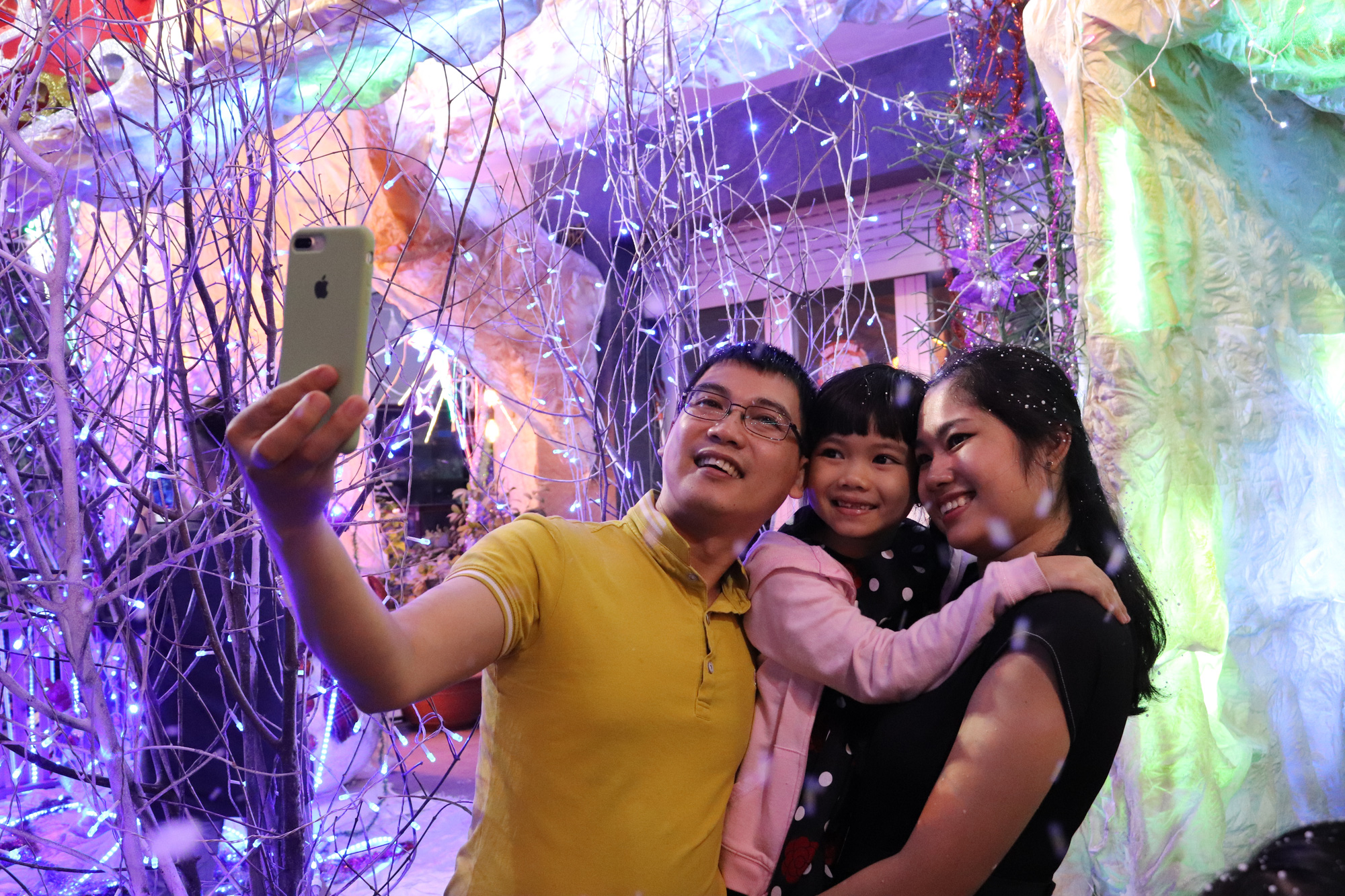 A family takes a photo at a Christian neighborhood in District 8. Photo: Khanh Tran / Tuoi Tre