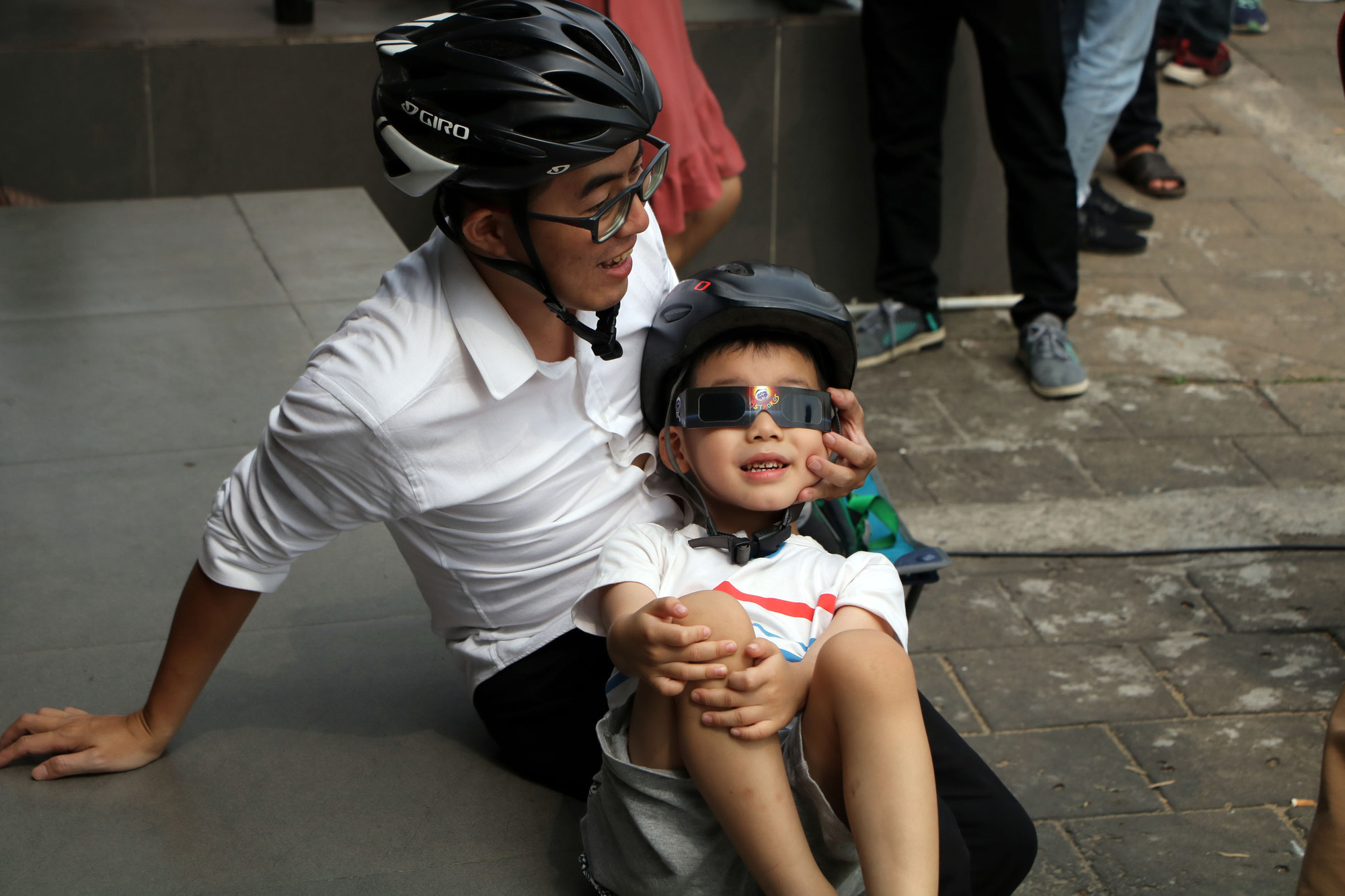 A father and his son view a solar eclipse in Ho Chi Minh City on December 26, 2019. Photo: Trong Nhan / Tuoi Tre