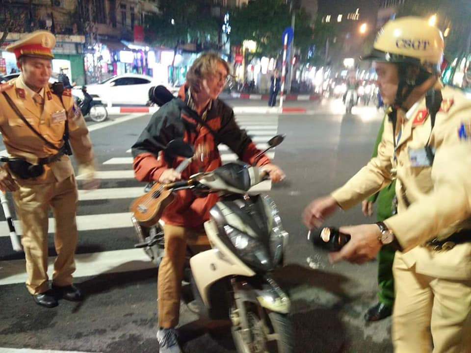 Russian Aleks Ivanov takes his motorbike to the side of the street after being stopped by traffic police in Hanoi on January 7, 2020. Photo: Xuan Bui / Tuoi Tre