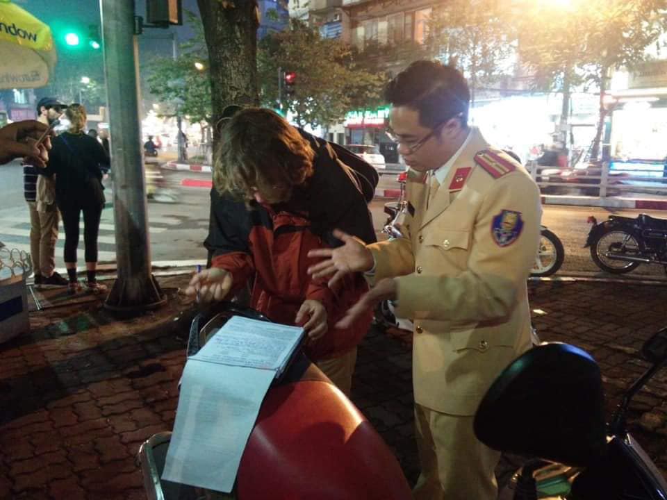Russian Aleks Ivanov is booked for failure to present a driver’s license and not wearing a crash helmet while riding a motorbike by traffic police in Hanoi on January 7, 2020. Photo: Xuan Bui / Tuoi Tre