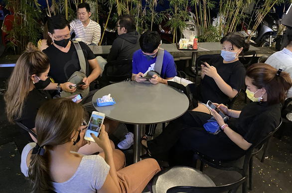 A group of youngsters in Ho Chi Minh City are seen wearing face masks while sitting at a local coffee shop on the night of January 26, 2020. Photo: Tuoi Tre/ Tu Trung
