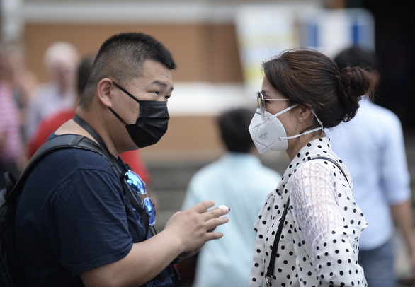 Two people communicate through face masks on the street in Ho Chi Minh City. Photo: Tuoi Tre/ Tu Trung