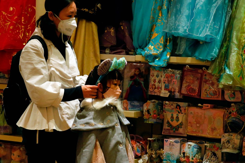 A child wears mask as she tries a themed ears at a souvenir shop in Disneyland hotel after Hong Kong Disneyland that has been closed, following the coronavirus outbreak in Hong Kong, China January 26, 2020. REUTERS/Tyrone Siu