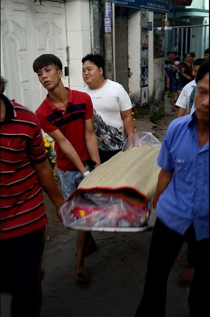 Local residents carry a body to the ambulance. Photo: Ai Nhan / Tuoi Tre