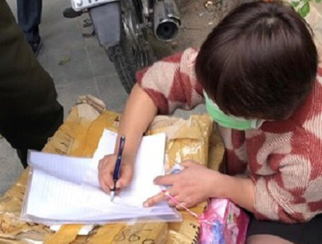 A hawker is booked for selling face masks at a high price in Hanoi in this photo supplied by police officers.