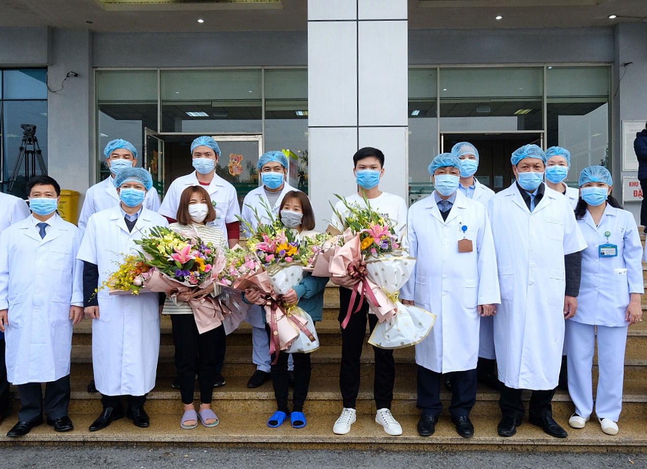 Three recovered novel coronavirus patients take a photo with doctors at the National Hospital for Tropical Disease in Hanoi, February 10, 2020. Photo: Nam Tran / Tuoi Tre