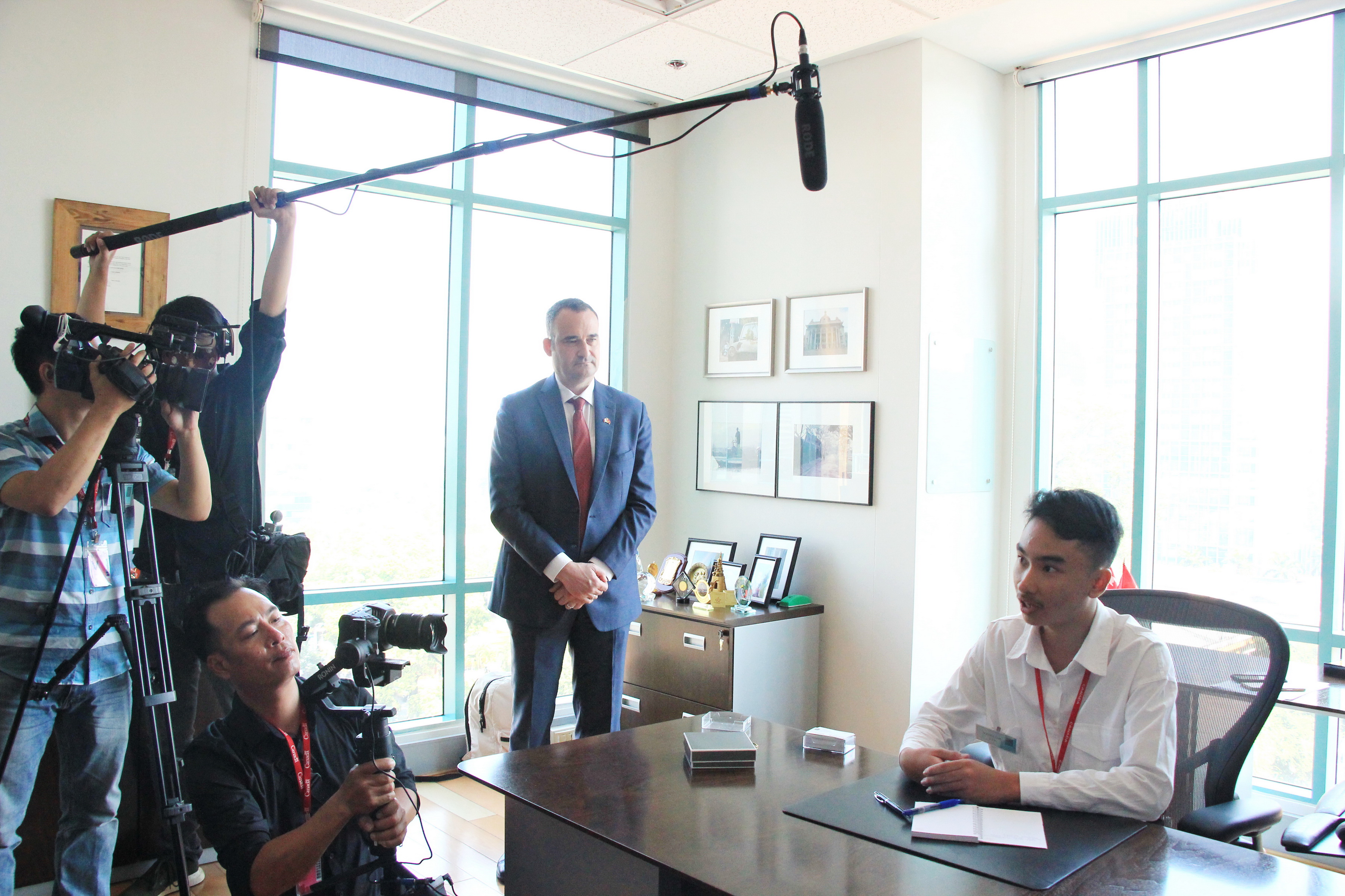 Canadian Consul General Kyle Nunas looks at ninth grader Le Huy Tuan while he poses to local media when he comes to the Consul General of Canada in Ho Chi Minh City to receive his 'duty' on February 19, 2020. Photo: Dong Nguyen/Tuoi Tre News