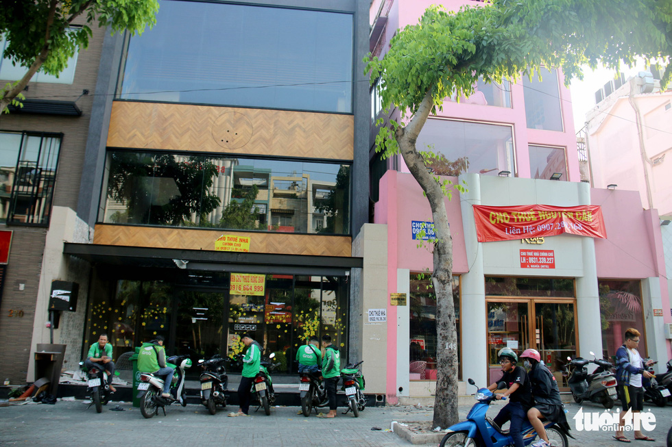 GrabBike drivers park their motorbikes in front of a building, where a coffee shop once operated, that is now up for rent on Phan Xich Long Street in Phu Nhuan District, Ho Chi Minh City. Photo: Ngoc Hien / Tuoi Tre