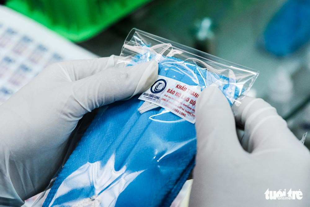A worker packages finished face masks at a raincoat factory in Dong Anh District, Hanoi, Vietnam. Photo: Mai Thuong / Tuoi Tre