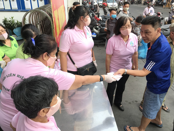 Face masks are distributed for free to residents of the 'backpacker area' in District 1, Ho Chi Minh City, March 15, 2020. Photo: Le Phan / Tuoi Tre 